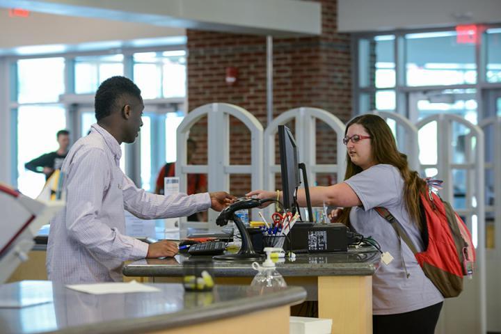 students at check out desk