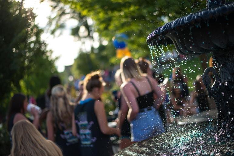 喷泉中水滴的艺术照片, 背景模糊的学生, 用荷兰角拍摄的 